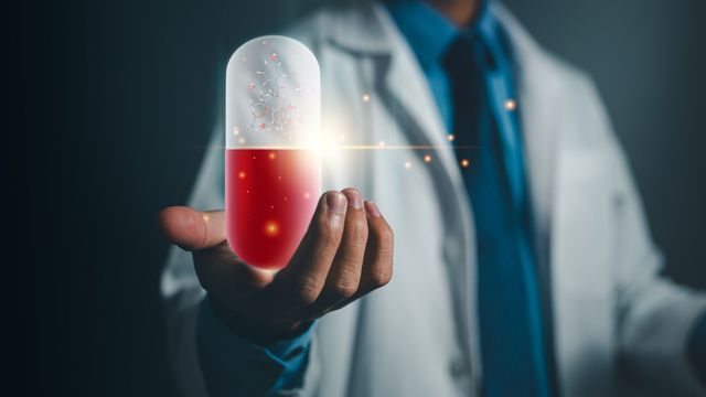 Doctor holding a glowing capsule representing AI-driven drug discovery and pharmaceutical innovation. 