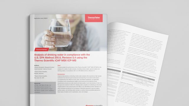 A hand holding out a glass of drinking water 